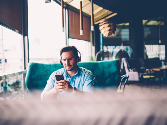 Man listening to music on phone in coffee shop